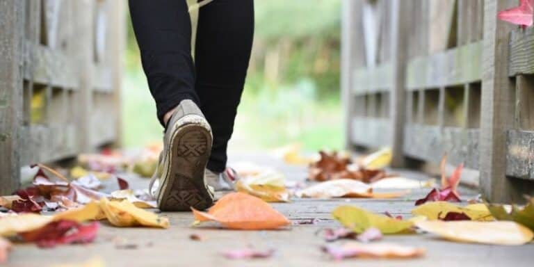 feet walking on coloured autumn leaves